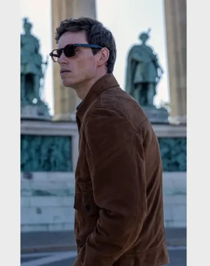 Side profile of Eddie Redmayne in the sleek suede jacket from The Day of the Jackal series.