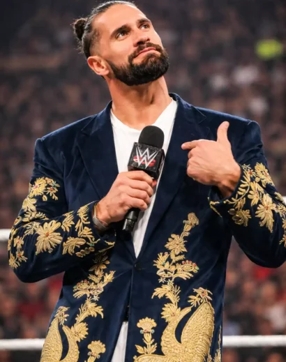 confident-pose-golden-peacock-long-coat-live-event Man posing confidently in golden peacock long coat during live event