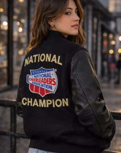 Back view of woman wearing NCA National Champion varsity jacket with embroidered National Cheerleaders Association logo.
