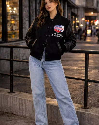 women-nca-varsity-jacket-front-model Female model wearing NCA varsity jacket front view with leather sleeves and National Cheerleaders Association patch.