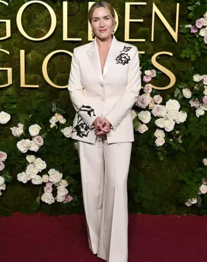 Kate Winslet floral suit pose with hand in pocket, wearing a stylish white coat outfit with black floral embroidery