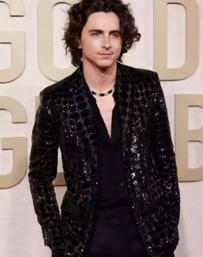 Timothee Chalamet black tuxedo look with sparkly coat and elegant red carpet pose