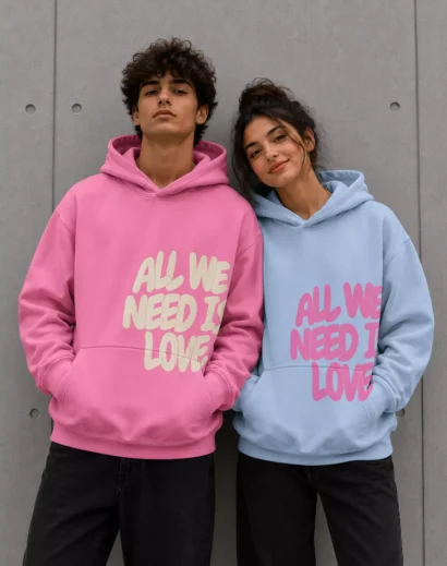 Couple wearing All We Need Is Love Oversized Hoodie, men in pink hoodie and women in blue hoodie streetwear fashion look