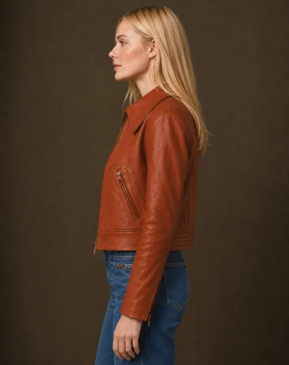 Margo’s Got Money Troubles Event Elle Fanning Orange Jacket left side profile featuring the Margo Millet orange jacket style. Premium women leather jackets in cognac brown, ideal as a women motorcycle jacket and brown leather jacket women.
