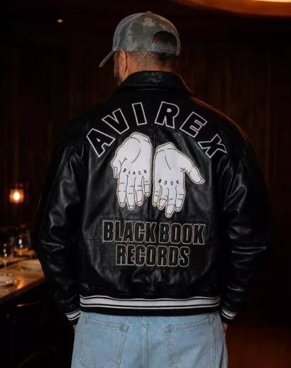 Back view of a black leather varsity jacket for men featuring large embroidered graphics inspired by the Avirex Letterman Jacket, Avirex Black Leather Varsity Jacket, and Avirex Embroidered Leather Jacket. A retro varsity jacket designed for streetwear and biker style fashion.