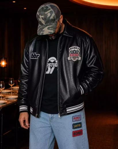 Front view of a men's oversized leather bomber jacket crafted from premium leather with embroidered details. This black bomber leather jacket reflects the classic Avirex Black Leather Jacket, Avirex USA Jacket, and genuine leather varsity jacket style for everyday urban wear.
