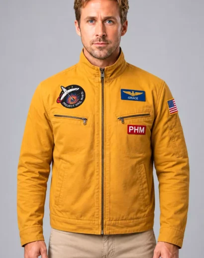 Ryan Gosling space jacket in mustard yellow with Project Hail Mary embroidered patch, Grace and PHM details, zip pockets and comfortable unisex outerwear design.
