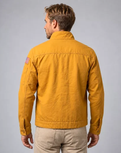 Mustard cotton jacket back view with clean vintage workwear styling, raised collar, detailed stitching and American flag sleeve patch inspired by Project Hail Mary.
